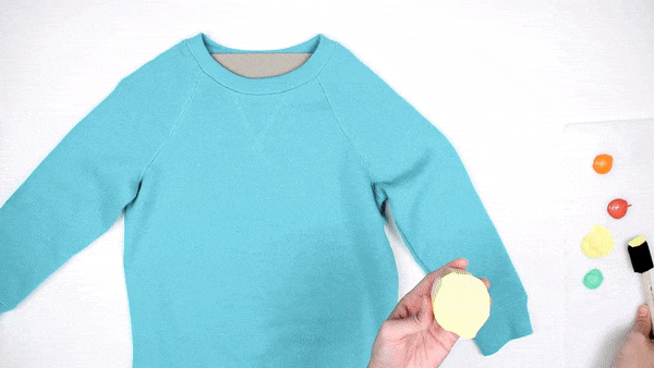 pressing fruit shape onto sweatshirt for stamping DIY