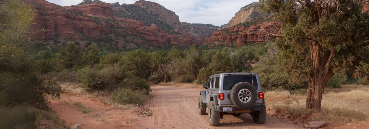 Jeep Wrangler going through red rock on Loy Butte Road in AZ