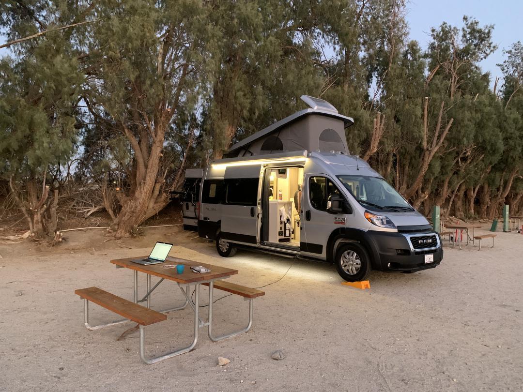 A camper van parked in a dirt area