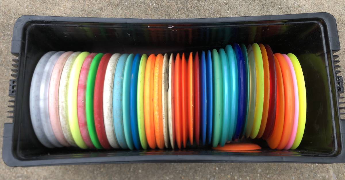 A plastic container filled with disc golf discs