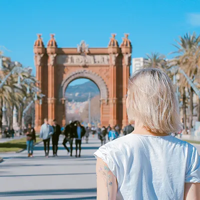 Woman walking towards arch.