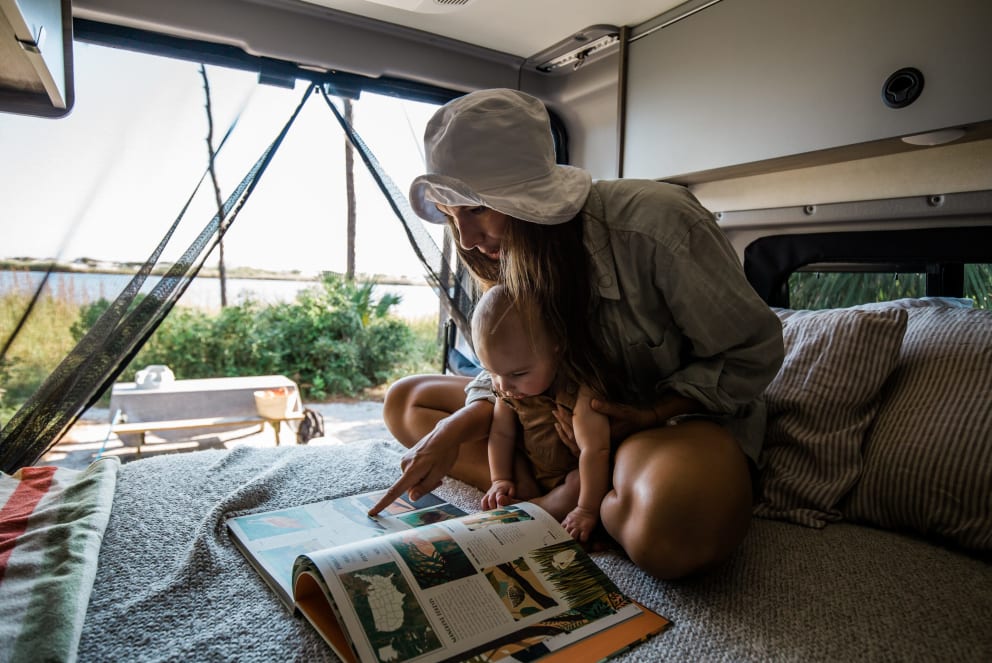 woman and son inside winnebago solis at campground