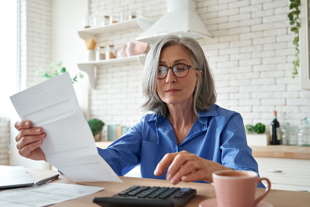 Woman with a calculator looking at a bill