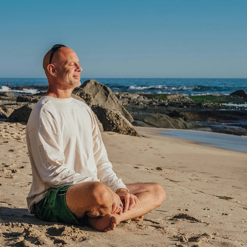 ManMeditating_onBeach.webp