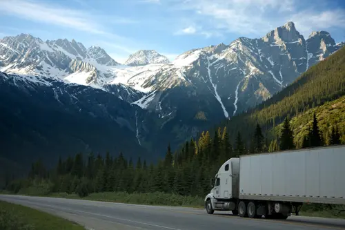 A truck on a scenic highway with a mountain view