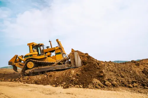 A bulldozer pushing dirt up an incline