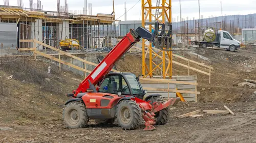 Red telehandler parked at a job site
