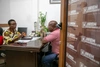 Two people having a conversation at a desk in an office setting