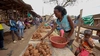 A young woman setting up her stand selling ground provisions at a marketplace in Kyaka II refugee settlement, Uganda 2026