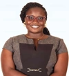 Flavia Anena wearing a light and dark brown dress and smiling