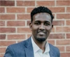 Hamdi Mohamed in a dark grey suit and white button up shirt