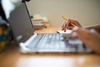 A persons hands working on a laptop