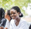 A young student sitting with classmates.