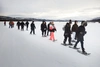 A group of people snowshoeing.