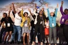 A group of women cheering on stage at an event.