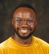 (Peter) Odero Otieno wearing eye glasses and a bright yellow t-shirt
