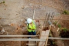 Gisele Umulisa travaille sur un chantier de construction avec un casque et un gilet de haute visibilité