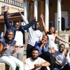 Group of Scholars grouped on steps outside smiling and celebrating 