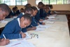 Young people writing in books in a classroom