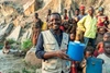 Oliver Nihimbazwe holding a container of clean water in Burundi