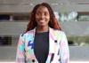 Woman smiling to camera in a brightly coloured jacket