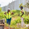 Gisele Umulisa et un collègue travaillant sur un chantier en casque et gilet de haute visibilité