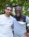 Two men standing side by side smiling at the camera.