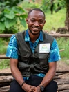 Nelson Papi Kolliesuah sitting outside in a vest