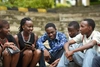 A group of people sitting together, talking and smiling.