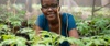 Phenny Omondi smiles to camera surrounded by plants