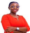 Joan Mugaba wearing a red quarter sleeve dress and smiling