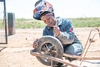 Mariam Sulaiman smiling and wearing her protective welding gear, in Kakuma refugee camp, Kenya, 2026