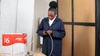 A young person in dark blue coveralls plugging in a device