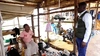 James Gihoma Ntakiruti standing inside a shoe stall in a marketplace at Kyaka II refugee settlement, Uganda 2026