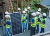 A group of young people in hard hats and high-vis vests, learning about solar panel installation, photo courtesy of Instersollar, Green RISE Africa, Pan-African Programs, March 25, 2026.
