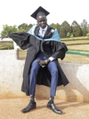 Kuol on his graduation day at Moi University wearing cap and gown