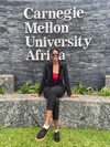 Akpene sitting in front of the CMU Africa sign