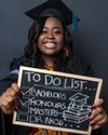 Elma holding up a to do list on a blackboard list to camera