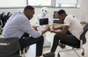 Deux hommes assis en train de discuter avec un robot au milieu