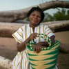 A woman sitting on a tree branch with a basket.