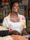 A young woman in a store selling dried beans and pulses.