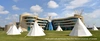 Tents on grass in front of a modern building