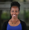 Angela Kileo smiles to camera in a blue top and black cardigan