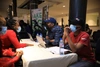 Group of people sat around a table in face masks