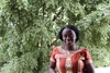 Florence stands smiling to camera with a tree in the background