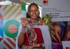 Young Kenyan woman entrepreneur showcasing her handmade crafts from her business.