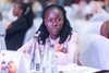 A young woman participant in the Young Africa Works Dialogue event sitting at a table wearing a light link shirt