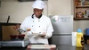 A young woman chef preparing food in a kitchen, wearing chefs attire