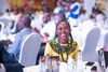 A young woman in a brightly coloured shirt with a bold pattern smiles at the Young Africa Works Dialogue Uganda event 2025