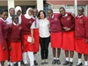 A group of schoolchildren in red uniform, standing with Reeta Roy, the Foundation's President and CEO.